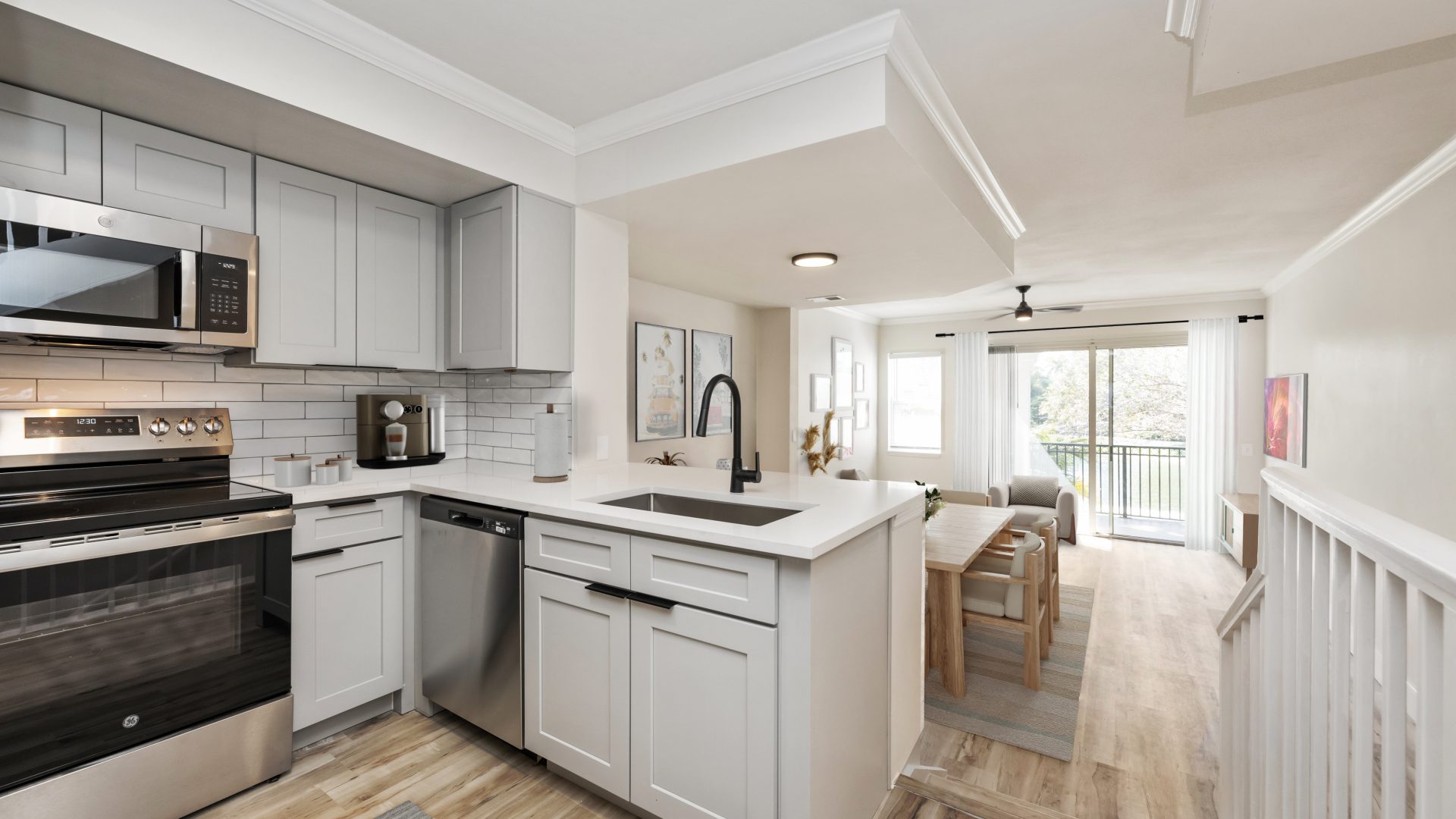 a kitchen with stainless steel appliances and white cabinets at The Palm Haven