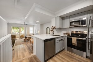 a kitchen with stainless steel appliances and wood floors at The Palm Haven