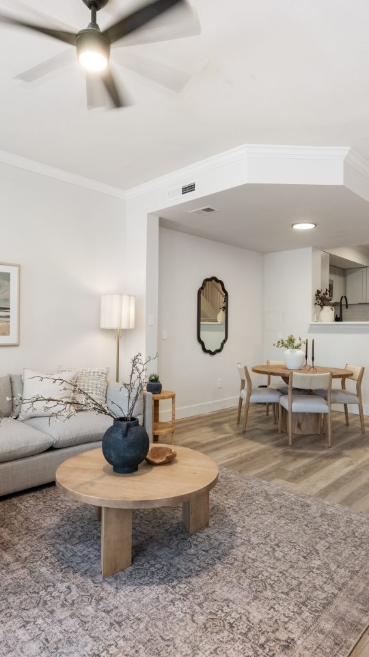 a living room with a ceiling fan and hardwood floors at The Palm Haven